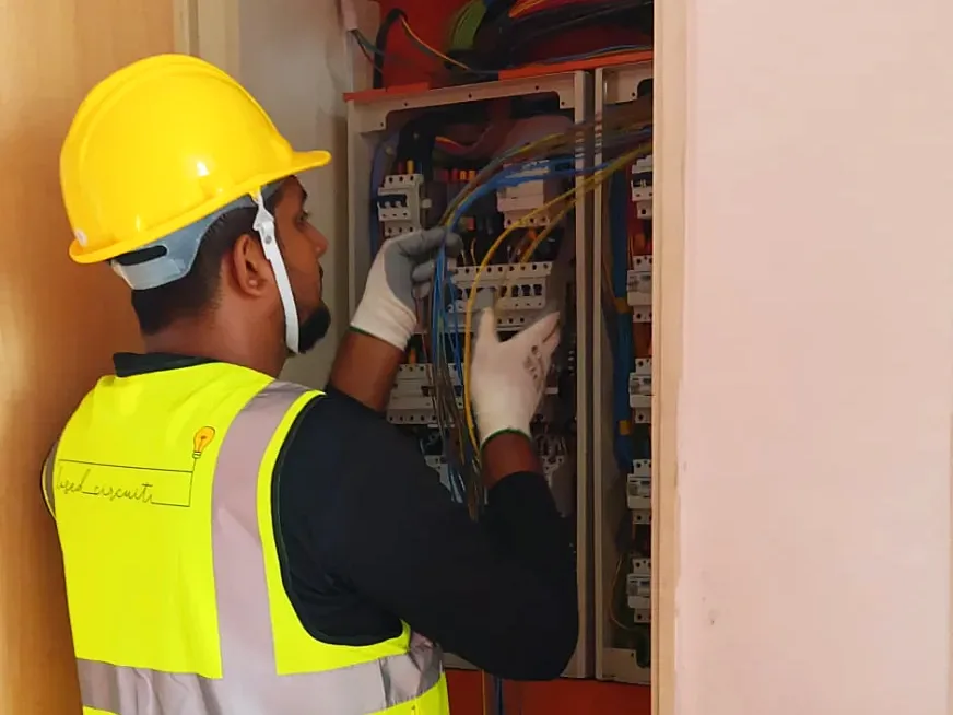 Technician wiring an electrical distribution board