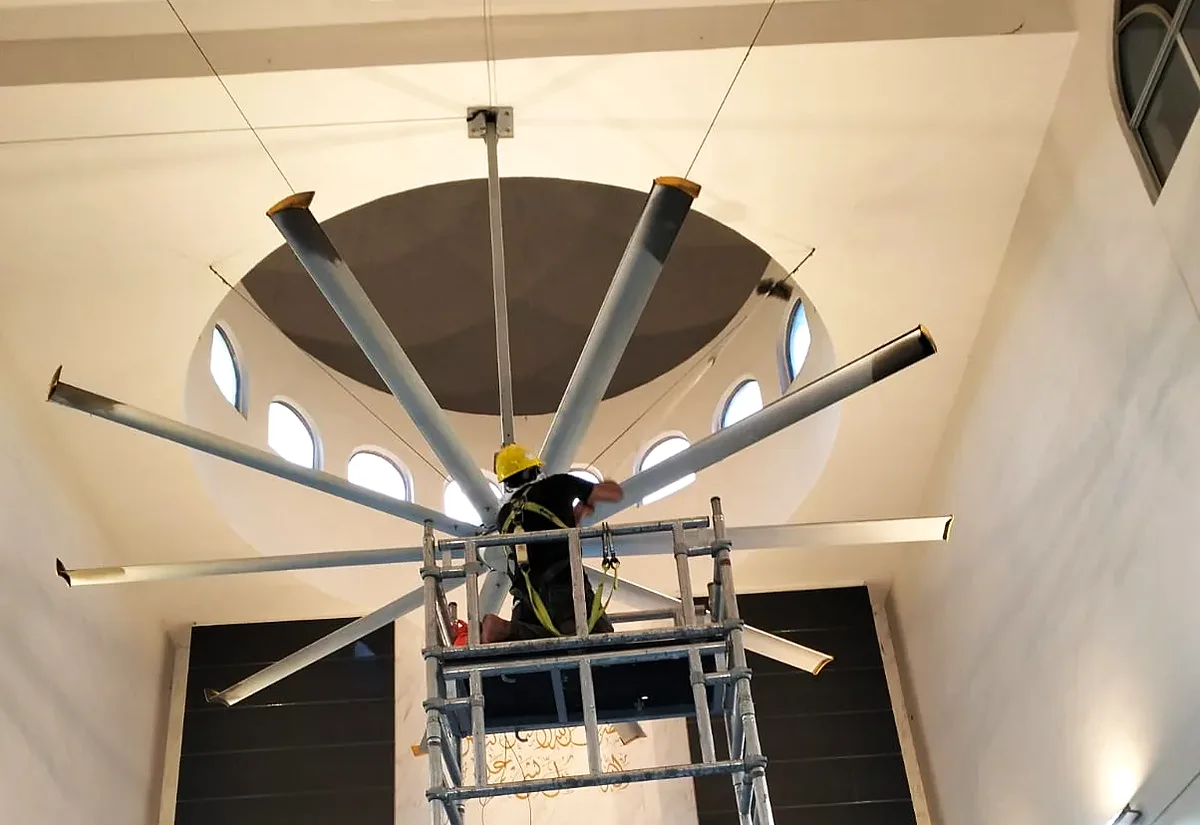 Our technician servicing a large HVLS fan in a high-ceiling hall